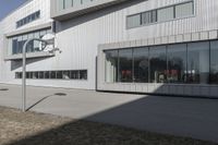 an office building with many windows in front of it, and outside seating area behind the glass door