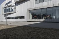 an office building with many windows in front of it, and outside seating area behind the glass door