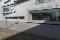 an office building with many windows in front of it, and outside seating area behind the glass door