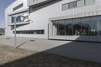 an office building with many windows in front of it, and outside seating area behind the glass door