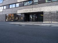 a picture of the entrance to a building that is located near a street with cars in front