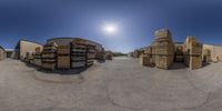 the spherical view shows multiple stacks and pallets in front of a building and the sun in the background