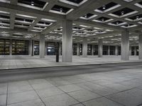 a room with rows of concrete columns on both sides and a brick floor and wall