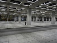 a room with rows of concrete columns on both sides and a brick floor and wall