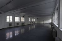 a room filled with windows and floors in an empty building with a dark gray floor