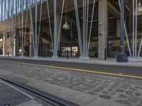 a city building with a few metal rods around it near a train track and tracks