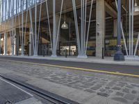 a city building with a few metal rods around it near a train track and tracks