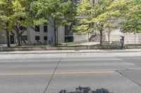 this is a parking meter in front of the city building on a street corner with trees, benches and parking meters