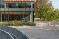 the exterior is very large and modern, but the sidewalk is quiet in front of the building