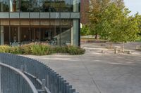 the exterior is very large and modern, but the sidewalk is quiet in front of the building