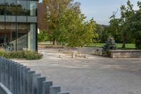 the exterior is very large and modern, but the sidewalk is quiet in front of the building