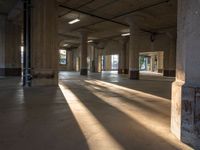 sunlight is seen coming in the windows of a building and creating its shadow on the concrete