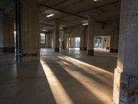 sunlight is seen coming in the windows of a building and creating its shadow on the concrete