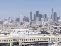 a city skyline with skyscrapers behind it and cars parked below the buildings on the lot