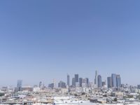 a city skyline with skyscrapers behind it and cars parked below the buildings on the lot