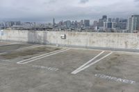 two parking spaces on a concrete roof with a view of city buildings in the background