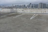 two parking spaces on a concrete roof with a view of city buildings in the background