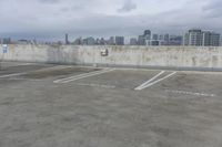 two parking spaces on a concrete roof with a view of city buildings in the background