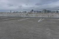 two parking spaces on a concrete roof with a view of city buildings in the background