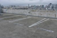 two parking spaces on a concrete roof with a view of city buildings in the background