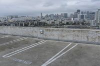 two parking spaces on a concrete roof with a view of city buildings in the background