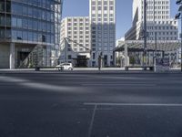 there is a person walking on the street in the daytime sun in the city center