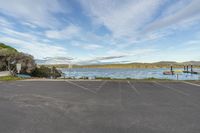 a large parking lot is shown by the lake with several boats on it and one is empty