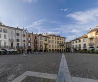 the large square is filled with people and architecture at a city corner in italy, near a park