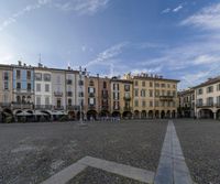 the large square is filled with people and architecture at a city corner in italy, near a park