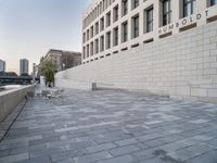 there is a brick walkway in front of a building with a white brick wall on the side