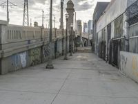 an empty street that is lined with graffiti, power lines and telephone poles at either end