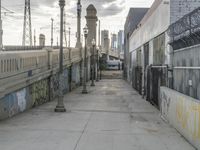 an empty street that is lined with graffiti, power lines and telephone poles at either end