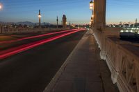 an image of some lights on a city street at night time on the bridge, with blurry cars