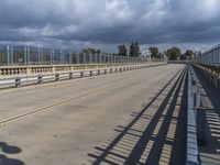 a train crossing a long bridge near an airport with a ramp and a person on a cell phone waiting