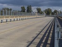 a train crossing a long bridge near an airport with a ramp and a person on a cell phone waiting