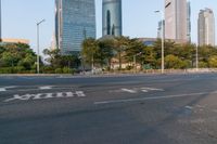 an intersection with the road empty and two way signs painted on it and some buildings in the background