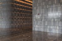 a hallway with a wall with vertical wood paneling on it with stainless plaque numbers on each side