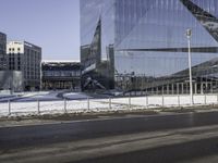 this is a view of the modern city building near the road side with snow on the ground