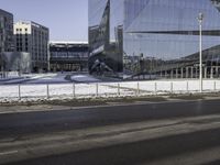 this is a view of the modern city building near the road side with snow on the ground