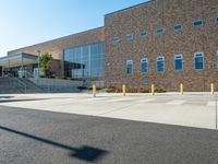 there is a sidewalk outside a high school building with stairs going up and down it