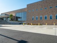 there is a sidewalk outside a high school building with stairs going up and down it