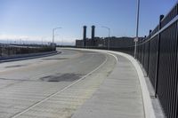 the highway leading to a big bridge and two towers near it and one with two cars on it