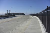 the highway leading to a big bridge and two towers near it and one with two cars on it