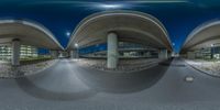 a 360 - view of an empty parking lot next to an overpass and some other buildings