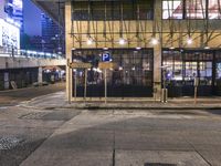 a bus stop with a blue cross walk sign and the exit sign for an underground subway station