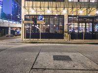 a bus stop with a blue cross walk sign and the exit sign for an underground subway station