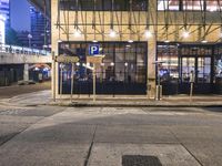 a bus stop with a blue cross walk sign and the exit sign for an underground subway station