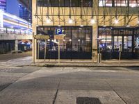 a bus stop with a blue cross walk sign and the exit sign for an underground subway station