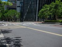 a city intersection with many buildings and trees on both sides of the road and on the sidewalk