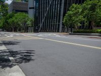 a city intersection with many buildings and trees on both sides of the road and on the sidewalk